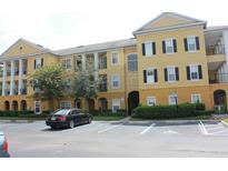 Attractive yellow apartment building featuring a well-maintained parking lot and landscaped surroundings at 3719 Conroy Rd # 2023, Orlando, FL 32839