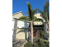 Beautiful two-story home with stone accents, desert landscaping, and bright red front door at 853 Ocean Course Ave # 853, Davenport, FL 33896