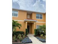 Inviting exterior of a two-story townhome with landscaping at 8968 California Palm Rd, Kissimmee, FL 34747