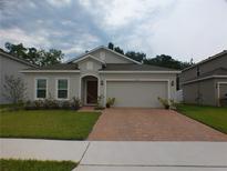 One-story home with a brick driveway and a two-car garage at 928 Avenal Ln, Davenport, FL 33837