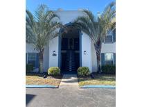 Two-story condo building with palm trees and a central staircase at 1014 Plantation Dr # A9, Kissimmee, FL 34741