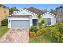 One-story home with gray siding, brick driveway and landscaping at 1404 Lexington Avenue, Davenport, FL 33837