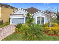 Charming single-Gathering home boasts a well-manicured lawn and an attached two-car garage at 1404 Lexington Avenue, Davenport, FL 33837