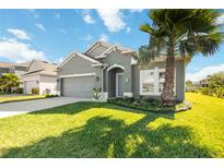 Charming single-story home with a well-maintained lawn, mature palm tree and manicured landscaping at 1813 Castleton Dr, St Cloud, FL 34771
