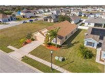 Single-Gathering home with a landscaped yard, driveway, and palm trees at 2542 Bobby Lee Ln, St Cloud, FL 34772