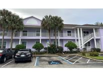 Purple two-story building with balconies, parking, and landscaping at 3133 Sun Lake Ct # B, Kissimmee, FL 34747
