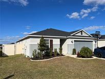 One-story home with gray siding, dark brown shutters, and a two-car garage at 503 Summer Grove Ln, Haines City, FL 33844