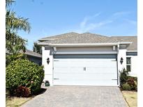 House exterior featuring a two-car garage and a paved driveway at 7637 Sand Pierre Ct, Kissimmee, FL 34747