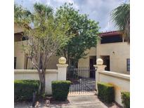 Charming courtyard entrance to home with mature trees and black iron gate at 10232 Turkey Lake Rd # 180, Orlando, FL 32819