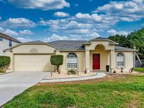 Single-story house with attached garage and landscaped lawn at 111 Robbins Rest Pl, Davenport, FL 33837