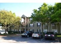 Exterior view of a multi-story apartment building with mature trees and visible parking at 2007 Dixie Belle Dr # 2007 I, Orlando, FL 32812