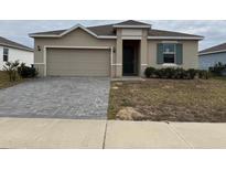 Newly constructed home with a two-car garage and well-manicured lawn at 231 Tarpon Bay Blvd, Haines City, FL 33844