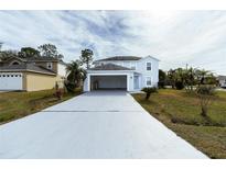 Two-story house with light blue exterior, a driveway, and landscaping at 945 Gateshead Ct, Kissimmee, FL 34758
