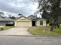 One-story house with a two-car garage and a well-maintained lawn at 1005 Tequesta Trl, Lake Wales, FL 33898