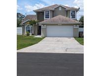 Two-story house with a white garage door and landscaped lawn at 1424 Sophie Way, Kissimmee, FL 34744