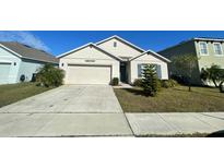 Well-maintained house with a two-car garage and manicured lawn at 3181 Serendipity Way, Davenport, FL 33896