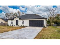 Newly constructed home with a gray roof, white exterior, and a dark gray garage door at 937 Elkcam Blvd, Deltona, FL 32725