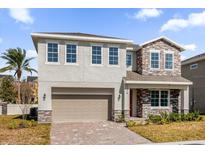 Two-story house with stone accents and a two-car garage at 1248 Ash Tree Cv, Casselberry, FL 32707