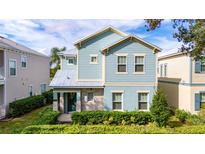 Two-story house with light blue siding, stone accents, and a landscaped front yard at 1432 Reunion Blvd, Reunion, FL 34747