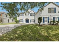 Charming two-story home featuring a brick driveway, beautiful lawn, and dark blue shutters at 3209 Eagle Watch Dr, Kissimmee, FL 34746