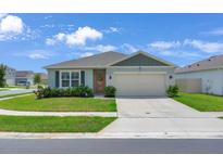 Charming single-story home with a well-manicured lawn and a two-car garage on a sunny day at 401 Chayne Pl, St Cloud, FL 34771
