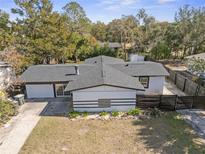 An aerial view of a white single-story home with a black roof, accented by a manicured yard and mature trees at 45 S Edgemon Ave, Winter Springs, FL 32708