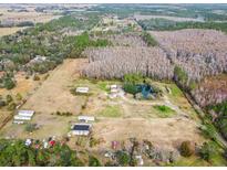 Aerial view of property with pond, multiple structures, and surrounding land at 4771 Deen Still Rd, Polk City, FL 33868