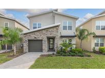 Two-story home with stone accents and a two-car garage at 771 Drop Shot Dr, Davenport, FL 33896