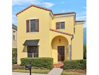 Beautiful yellow two-story house with landscaping and brown shutters at 1009 Wiregrass St, Celebration, FL 34747