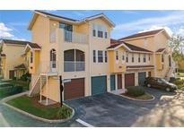 Exterior view of a two-story condo building with attached garages and balconies at 12209 Wild Iris Way # 110, Orlando, FL 32837
