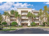 Elegant building exterior featuring balconies, lush landscaping, and handicap parking at 1350 Centre Court Ridge Dr # 401, Reunion, FL 34747