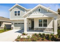 Charming two-story home with stone accents, a covered porch, and a two-car garage on a sunny day at 1503 August Gray Dr, Kissimmee, FL 34744