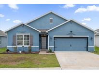 Charming one-story home with blue exterior and landscaping at 3027 Serendipity Way, Davenport, FL 33896