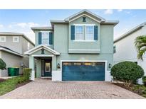 Charming two-story home featuring a brick driveway, teal shutters and a matching two-car garage door at 350 Pendant Ct, Kissimmee, FL 34747