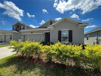 Gray house with two-car garage and landscaping at 4310 Seven Canyons Dr, Kissimmee, FL 34746