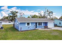 Charming blue single-story home with a well-manicured lawn and a driveway leading to an attached garage at 1507 Georgia Ave, St Cloud, FL 34769