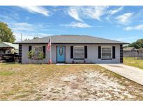 Charming single-story home with a bright blue front door and an American flag at 152 Harrison St, Lake Wales, FL 33859