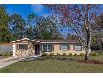 Charming single-story home with tan siding, brown shutters, well-manicured lawn, and mature landscaping at 3827 Anna Dr, Apopka, FL 32703