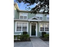 Charming townhouse with a dark green front door, white trim, and manicured landscaping at 4010 San Gallo Dr # 105, Kissimmee, FL 34741