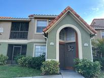 Two-story condo building with Spanish tile roofing and lush landscaping at 429 Fountainhead Cir # 122, Kissimmee, FL 34741