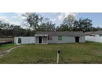 Single-story house with a gray exterior, dark roof, large yard and a surrounding fence at 608 S Lakeview Ave, Winter Garden, FL 34787