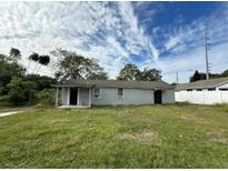 Exterior shot of a single-story home, featuring a simple design with a grassy front yard at 608 S Lakeview Ave, Winter Garden, FL 34787