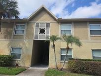 Exterior view of a two-story building with a light-colored facade and well-maintained landscaping at 9916 Sweepstakes Ln # 7, Orlando, FL 32837