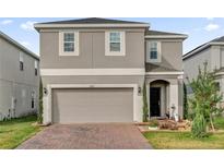 Charming two-story home with neutral paint, a two car garage and a well maintained, landscaped yard at 1669 Swan Swim Dr, Davenport, FL 33837