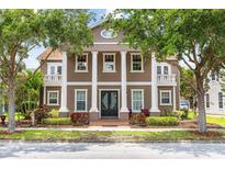 Stately two-story home featuring impressive white pillars, balconies, and mature trees at 3329 Schoolhouse Rd, Harmony, FL 34773