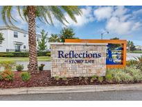 Reflections at Storey Lake community sign featuring stone detail, manicured landscaping and vibrant blue accents at 4740 Tribute Trl, Kissimmee, FL 34746