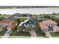 Stunning aerial view of a luxurious home with solar panels and a picturesque lake backdrop at 4959 Tennessee Lake Dr, Auburndale, FL 33823