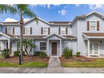 Charming townhouse features a well-manicured lawn, palm tree, and inviting entryway at 5360 Diplomat Ct # 107, Kissimmee, FL 34746