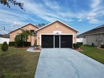 Charming single-story home with a well-maintained lawn and a screened two-car garage at 5674 Sycamore Canyon Dr, Kissimmee, FL 34758