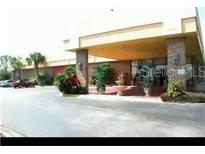 Inviting exterior view of the building's entrance, featuring well-maintained landscaping and ample parking at 7900 S Orange Blossom Trl # 2075, Orlando, FL 32809